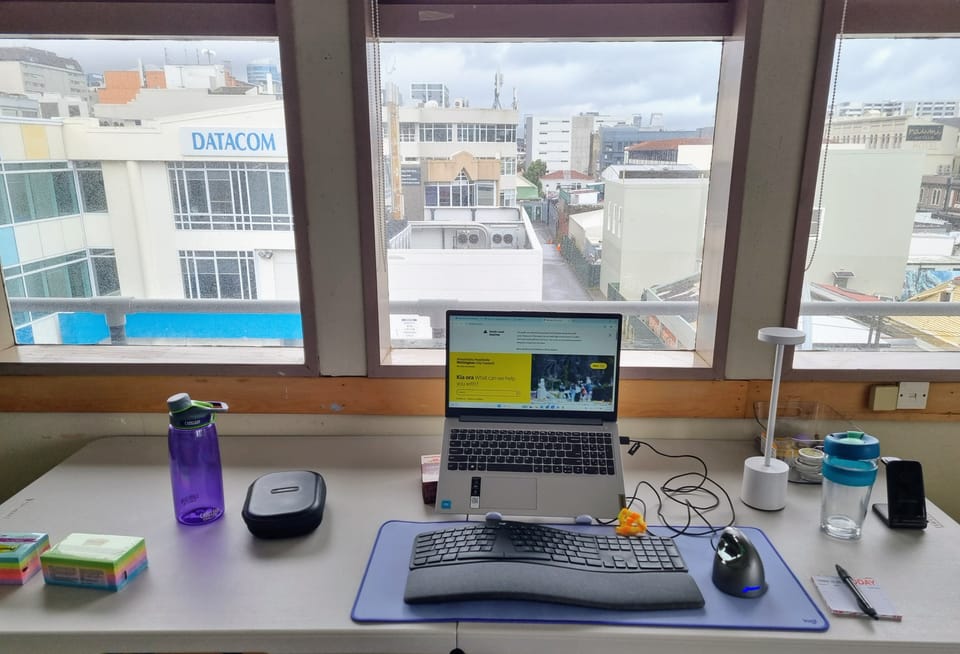 desk step up with laptop and keyboard, and various other items including keyboard and keep cup